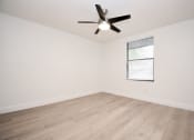 Thumbnail 11 of 36 - an empty living room with wood-style floors and a ceiling fan