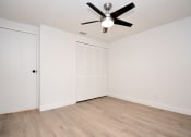 Thumbnail 12 of 36 - an empty living room with white walls and a ceiling fan