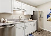Thumbnail 23 of 41 - A kitchen with white cabinets and a stainless steel refrigerator.