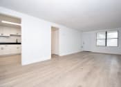 Thumbnail 14 of 36 - an empty living room and kitchen with white walls and wood-style floors