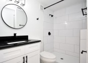Thumbnail 23 of 36 - a bathroom with a toilet and a sink and a mirror