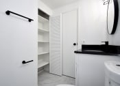 Thumbnail 24 of 36 - a white bathroom with a sink and a closet