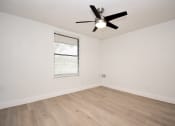 Thumbnail 19 of 36 - an empty living room with a ceiling fan and a window