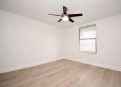 Thumbnail 21 of 36 - an empty living room with a ceiling fan and a window