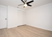 Thumbnail 22 of 36 - an empty living room with a ceiling fan and a closet