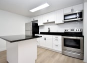 Thumbnail 26 of 36 - a kitchen with white cabinets and stainless steel appliances