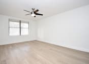 Thumbnail 28 of 36 - an empty living room with white walls and a ceiling fan