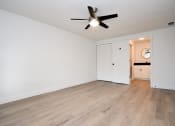 Thumbnail 29 of 36 - an empty living room with white walls and a ceiling fan