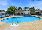 Thumbnail 34 of 41 - A swimming pool surrounded by lounge chairs and trees.