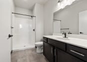 Thumbnail 15 of 25 - Brooke Street Lofts bathroom with a large sink vanity, toilet, and shower