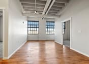 Thumbnail 8 of 25 - a living room with massive windows and high ceilings in an income-restricted Brooke Street Loft