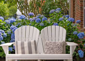 Thumbnail 4 of 56 - a pair of white adirondack chairs in front of a blue hydrangea at Fenwyck Manor