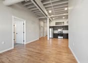 Thumbnail 2 of 25 - a large living room and modern kitchen with wood floors and high ceilings