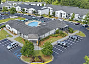 Thumbnail 41 of 41 - A large building with a pool in the middle of a parking lot.