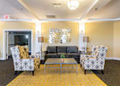 Thumbnail 12 of 26 - A living room with a grey couch, two chairs and a coffee table.