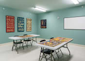 Thumbnail 20 of 26 - A room with tables and chairs and a whiteboard on the wall.
