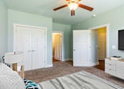 Thumbnail 7 of 26 - A living room with a ceiling fan and a television.