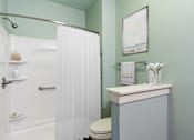 Thumbnail 8 of 26 - A white toilet sits next to a white sink in a bathroom.