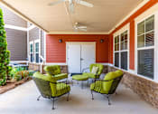 Thumbnail 23 of 26 - A patio with a white ceiling fan and four green chairs.