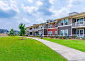 Thumbnail 3 of 26 - A row of houses with a green lawn in front.