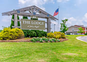 Thumbnail 1 of 26 - A sign for The Lodge stands in front of a building.