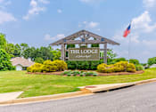 Thumbnail 26 of 26 - A sign for The Lodge at Pine Ridge stands in front of a green lawn.