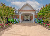 Thumbnail 2 of 56 - entrance to Fenwyck Manor Clubhouse with neat walkway and lush, mature landscaping