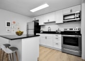 Thumbnail 3 of 36 - a kitchen with white cabinets and stainless steel appliances and a black counter top