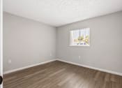 Thumbnail 3 of 37 - A room with a window and wooden flooring.