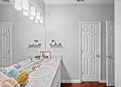 Thumbnail 36 of 56 - a bathroom with a sink, large vanity, and a mirror with overhead lighting