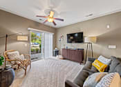 Thumbnail 26 of 56 - large living room with sliding glass doors to deck, illuminated ceiling fan, and model decor