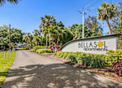 Thumbnail 7 of 37 - A street view of Bellas Apartments with a sign and a road.