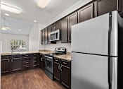 Thumbnail 2 of 28 - A modern kitchen with dark brown cabinets and a white refrigerator.