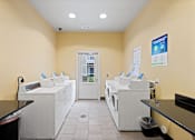 Thumbnail 49 of 56 - laundry center with washers, dryers, and folding tables at Fenwyck Manor