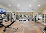 Thumbnail 38 of 56 - Fenwyck Manor's fitness center with cardio and strength equipment, a TV, and a mirrored wall