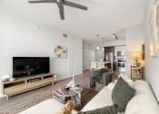 Thumbnail 26 of 40 - A modern living room with a white couch and a wooden coffee table.