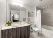 Thumbnail 23 of 40 - A bathroom with a white toilet, a sink, and a bathtub.