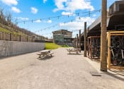 Thumbnail 22 of 43 - a seating area with picnic tables and bikes in front of a building