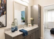 Thumbnail 30 of 44 - Modern bathroom with granite and ample cabinetry at Residences at The Green in Lakewood Ranch, FL