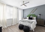 Thumbnail 29 of 44 - spacious bedroom with modern fan, wood-style floor, large window, and model decor