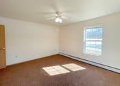 Thumbnail 16 of 24 - a spacious bedroom with baseboard heaters and a ceiling fan