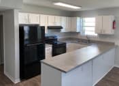 Thumbnail 1 of 2 - Renovated kitchen with black appliances, wood-style floors, and granite-inspired countertops