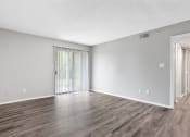Thumbnail 24 of 28 - the spacious living room with wood flooring and sliding glass doors