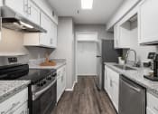 Thumbnail 4 of 28 - a kitchen with white cabinets and stainless steel appliances and granite counter tops