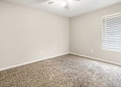 Thumbnail 13 of 18 - A room with a carpeted floor and a ceiling fan.