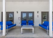 Thumbnail 21 of 28 - a patio with blue chairs and a coffee table