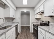 Thumbnail 20 of 28 - an empty kitchen with granite counter tops and white cabinets