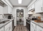 Thumbnail 2 of 28 - an open kitchen and dining room with a table in the distance