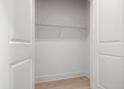 Thumbnail 10 of 37 - an empty closet in a home with white walls and wood floors