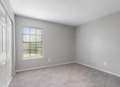 Thumbnail 26 of 28 - an empty living room with a window and carpet
